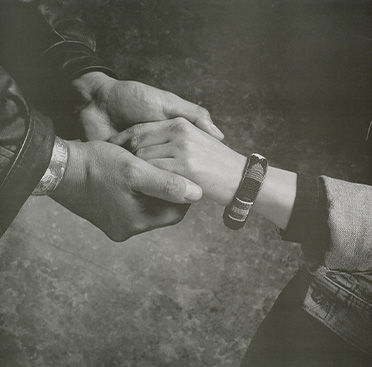 A poster with text and a black and white photograph of hands holding