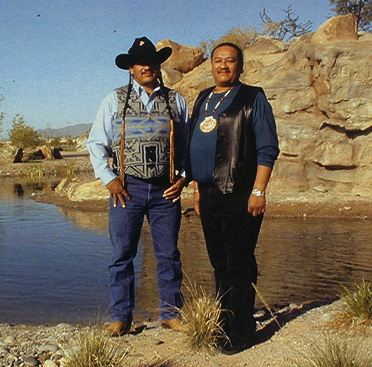 A poster with text and a photograph of two Native American men standing by a river