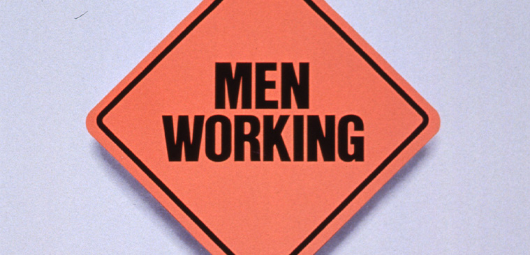 Orange square road sign that reads “Men Working” over text