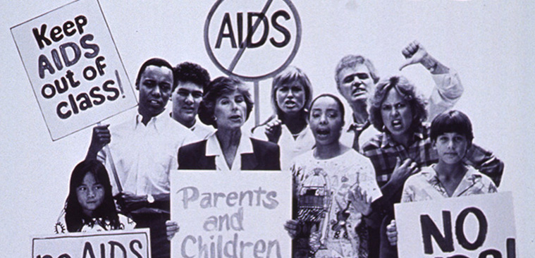 Black and white image of multiracial group of people holding various anti-AIDS signs