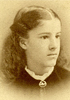 Teenage girl, visible from the shoulders up, looking in half profile to the right.