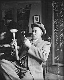 Peter M. Hoffman, Coroner, Cook County, examines a hammer used to murder George Dietz, April 18, 1913
