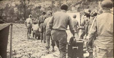 Army unit on the march, carrying a screen and 16mm projector, Italian campaign, 1944.