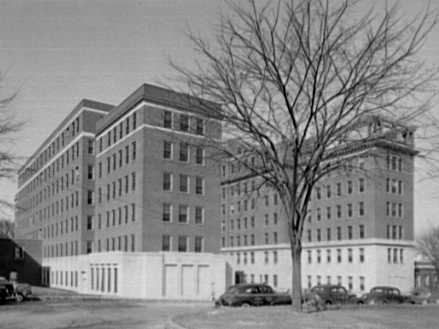 A black and white image of the Gallinger Municipal Hospital including 2 multi–story buildings with nearby trees.