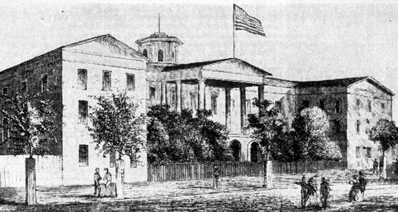A black & white front angle view of the Washington Infirmary Hospital- a multi-story building with a roof and large white columns at the entrance.