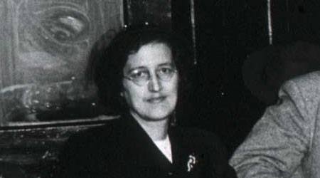 An informal black and white photograph of a white woman with dark hair in a suit.