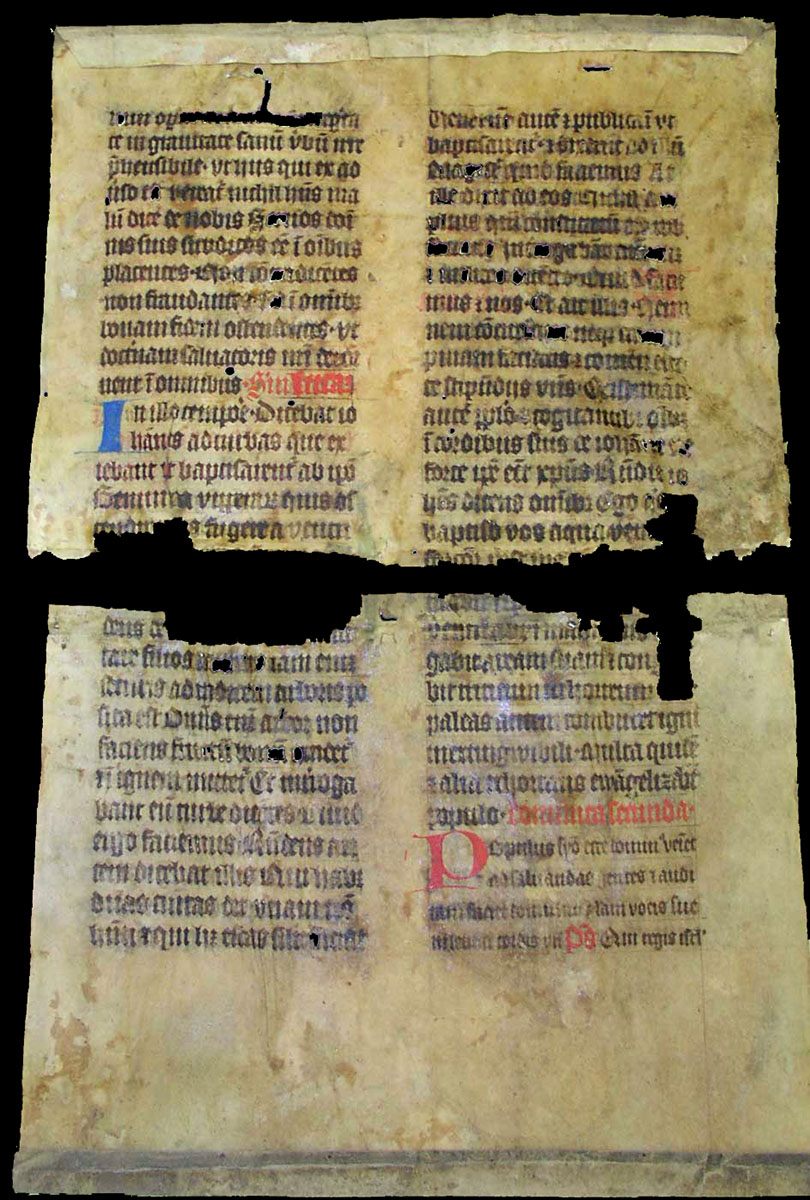 A torn vellum sheet with gothic writing and folded edges.