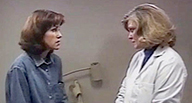 A woman talks with another woman in a white coat.