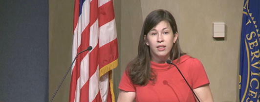 Young woman at a podium facing forward.