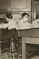 Girl clerks in New York at work with masks carefully tied about their faces.