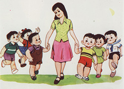 Slide showing a teacher, in a red skirt and green blouse, walks along holding the hands of two little boys who skip merrily beside her, with other children flanking both boys