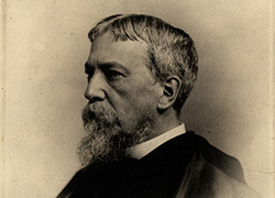 A photographic portrait of S. Weir Mitchell, bearded, head and shoulders, wearing a cape.