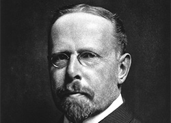 Formal Photogravure of a white man in a suit with a beard and glasses.