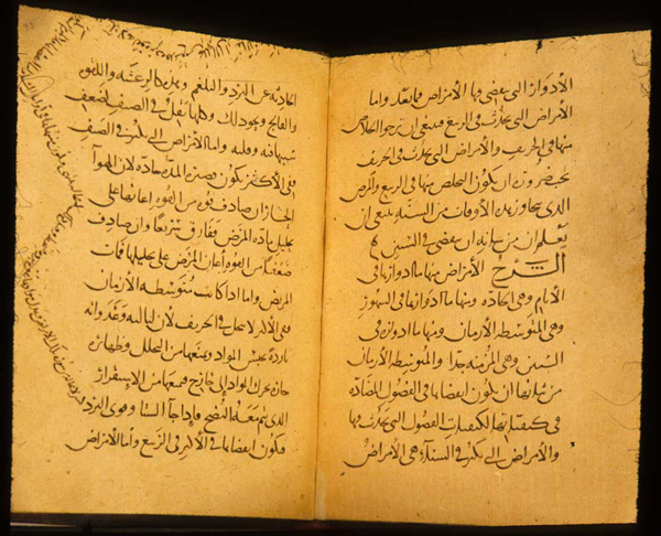 Book open with Arabic script on orange paper.