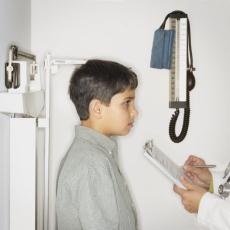 Photograph of a boy having his height measured