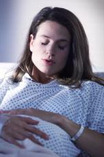 Photograph of a pregnant woman in the hospital experiencing a contraction