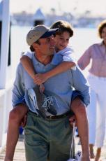 Fotografía de un padre cargando su hijo a caballito