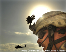 Fotografía de un soldado con un helicóptero en el fondo