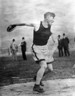 Black and white photograph of Jim Thorpe about to throw a discus, which he is holding is in his right hand.
