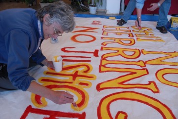Riki Ott Paints a banner against Supreme Court Exxon Valdez Court Ruling